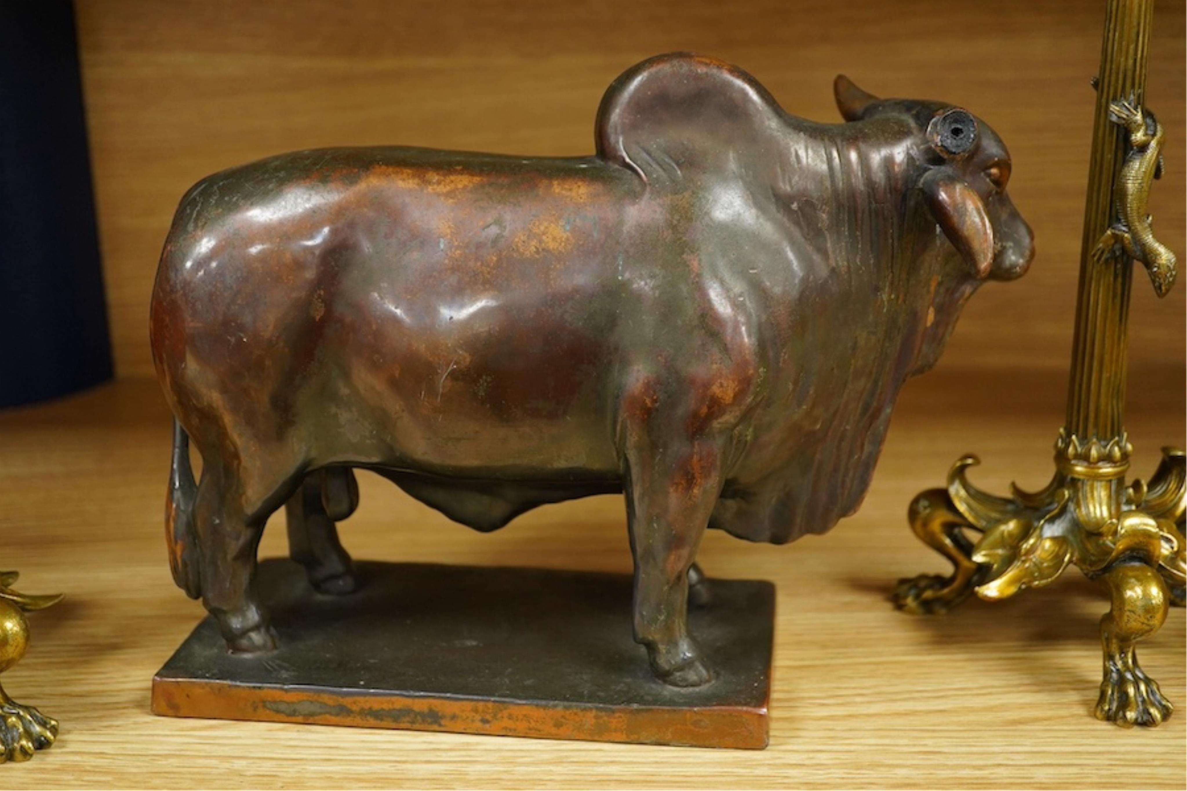 A patinated copper study, 'American Brahman', inscribed EtC, together with a pair of 19th century ormolu candlesticks, largest 30cm high. Condition - fair, bull missing one horn